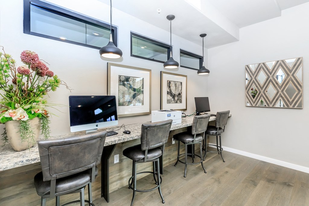 an office with a long desk with chairs and a computer