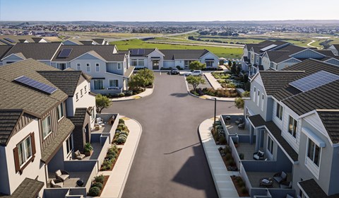A residential area with houses and solar panels on the roofs.