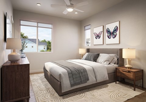 A bedroom with a large bed, a nightstand, and a ceiling fan.