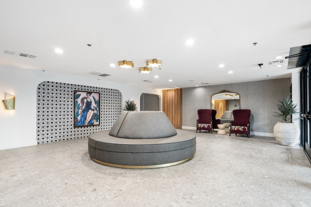 a lobby with a round couch and seating