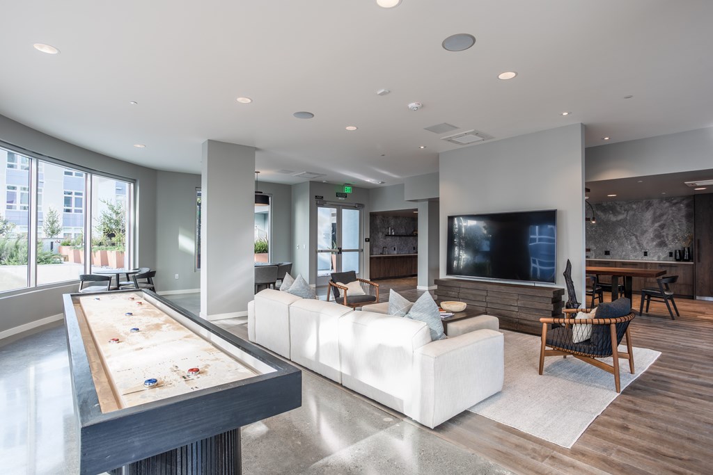 a large living room with a white couch and a pool table