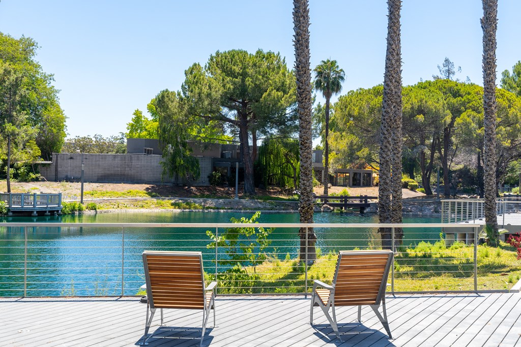 two chairs on a deck overlooking a lake