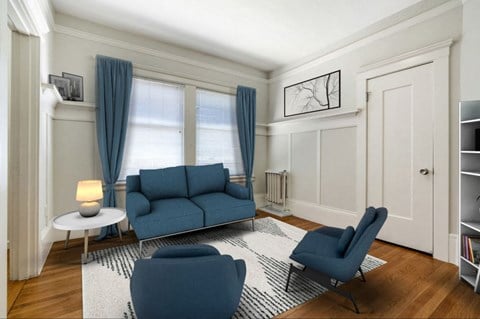 a living room with blue couches and chairs and a rug