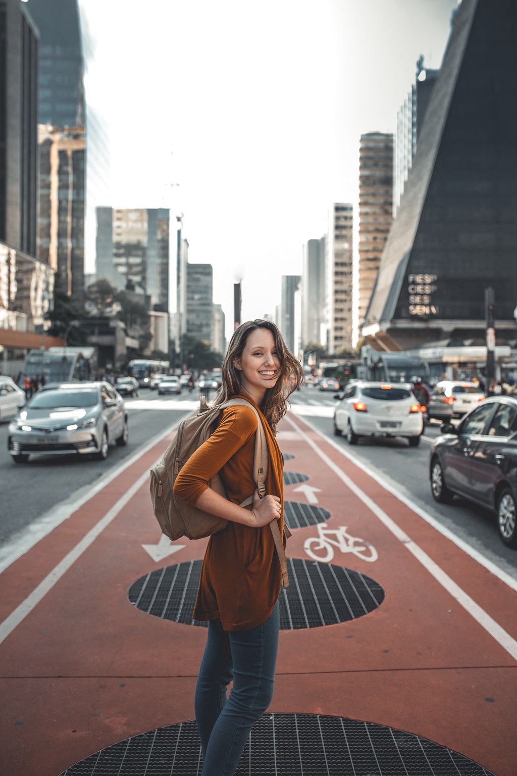 portrait of a young woman standing in the middle of a city street
