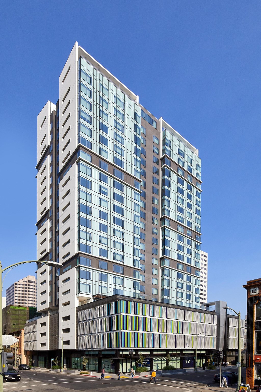 A modern multi-story building with glass windows and a street view in front.