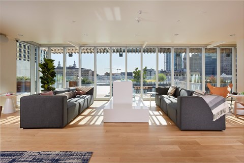 A living room with a grey couch and a white table.