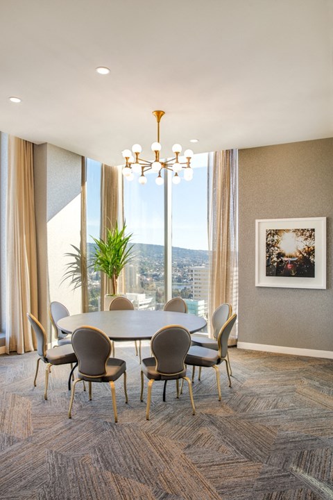 A dining room with a table and chairs and a view of the city.