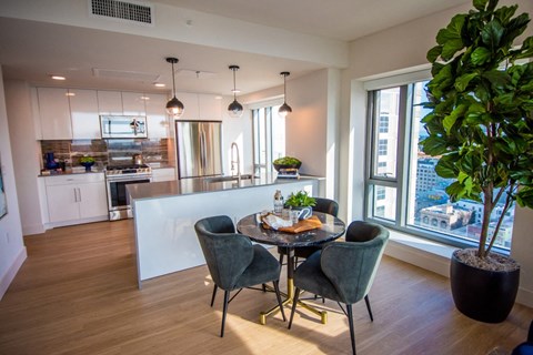 A modern kitchen with a dining table set for four.