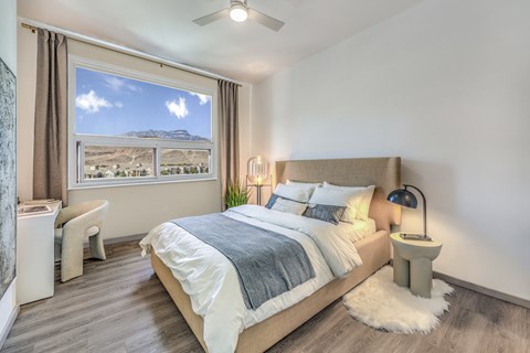 A bedroom with a large bed and a view of the mountains outside the window.