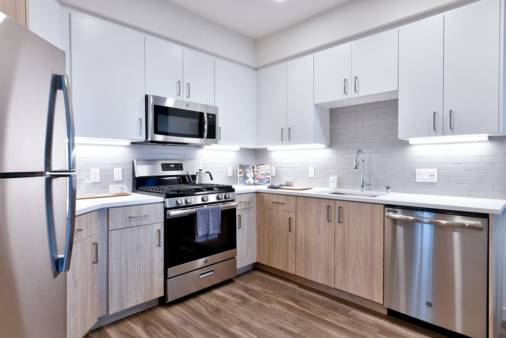 a modern kitchen with white cabinets and stainless steel appliances
