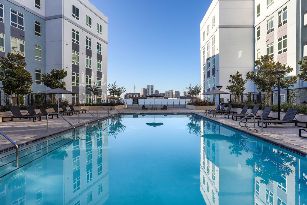 a large swimming pool in front of some tall buildings