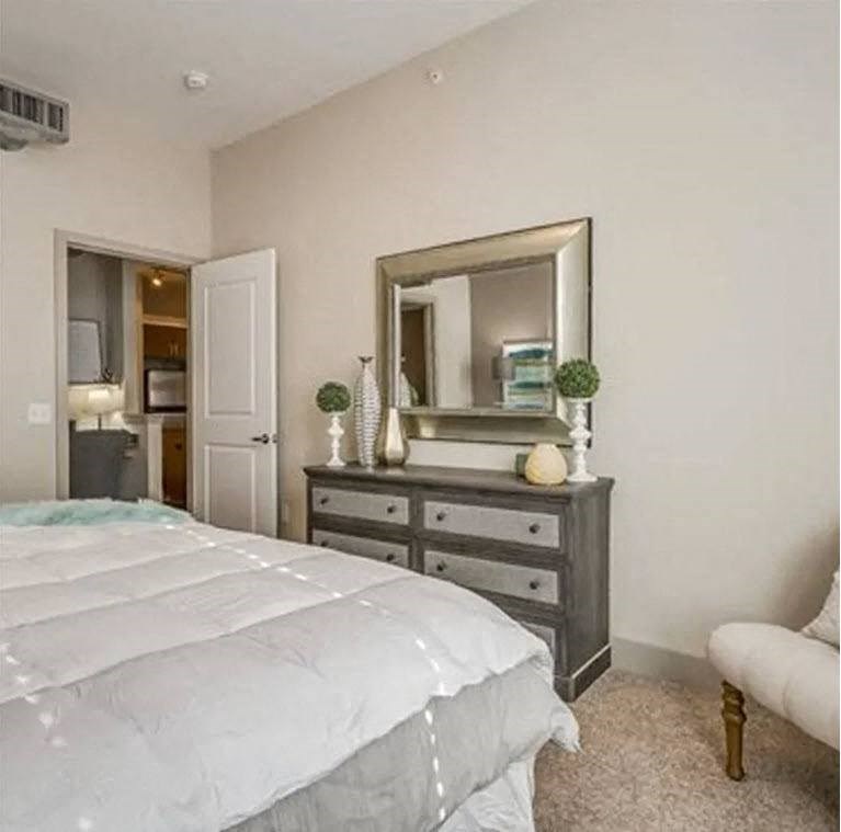 a bedroom with a bed and a dresser with a mirror at Trend Design District, Dallas