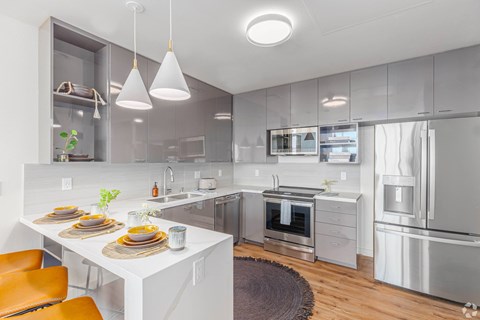 A modern kitchen with a white table and stainless steel appliances.