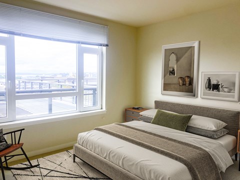 A bedroom with a large bed and a window overlooking a parking lot.