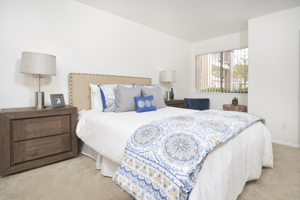 Thousand Oaks, CA, Apartments For Rent - The Knolls - Spacious Bedroom With Carpet Flooring, Bed, Nightstands with Lamps, and Window With Blinds