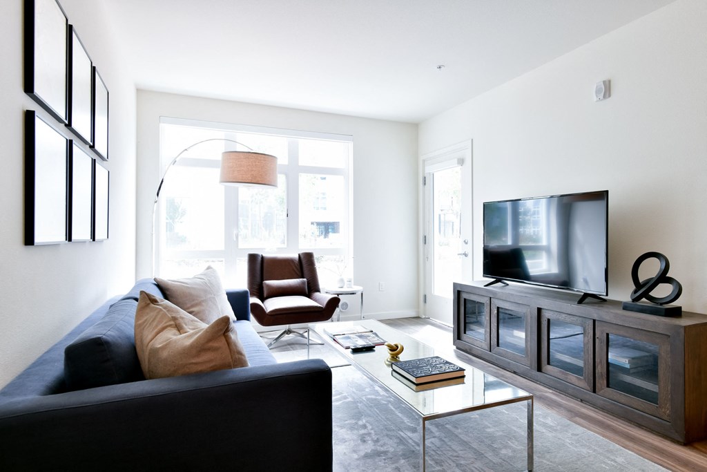 a living room with a black couch and a television