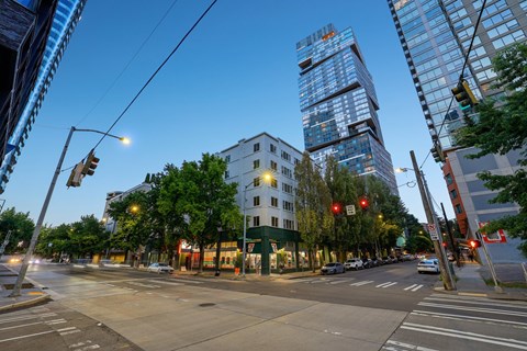 A city street with a traffic light and a building in the background.