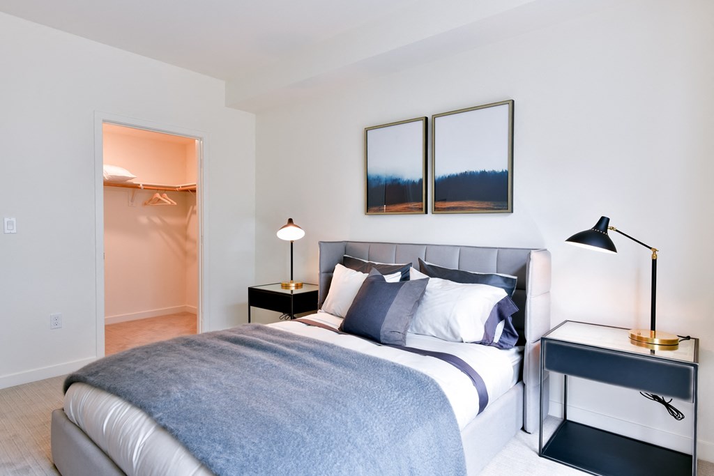 a bedroom with a bed and two lamps and a closet