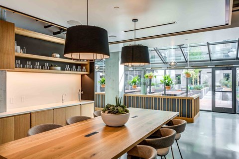 A modern dining area with a long wooden table and chairs.