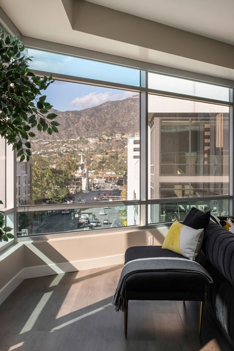 A living room with a couch and a view of the city.