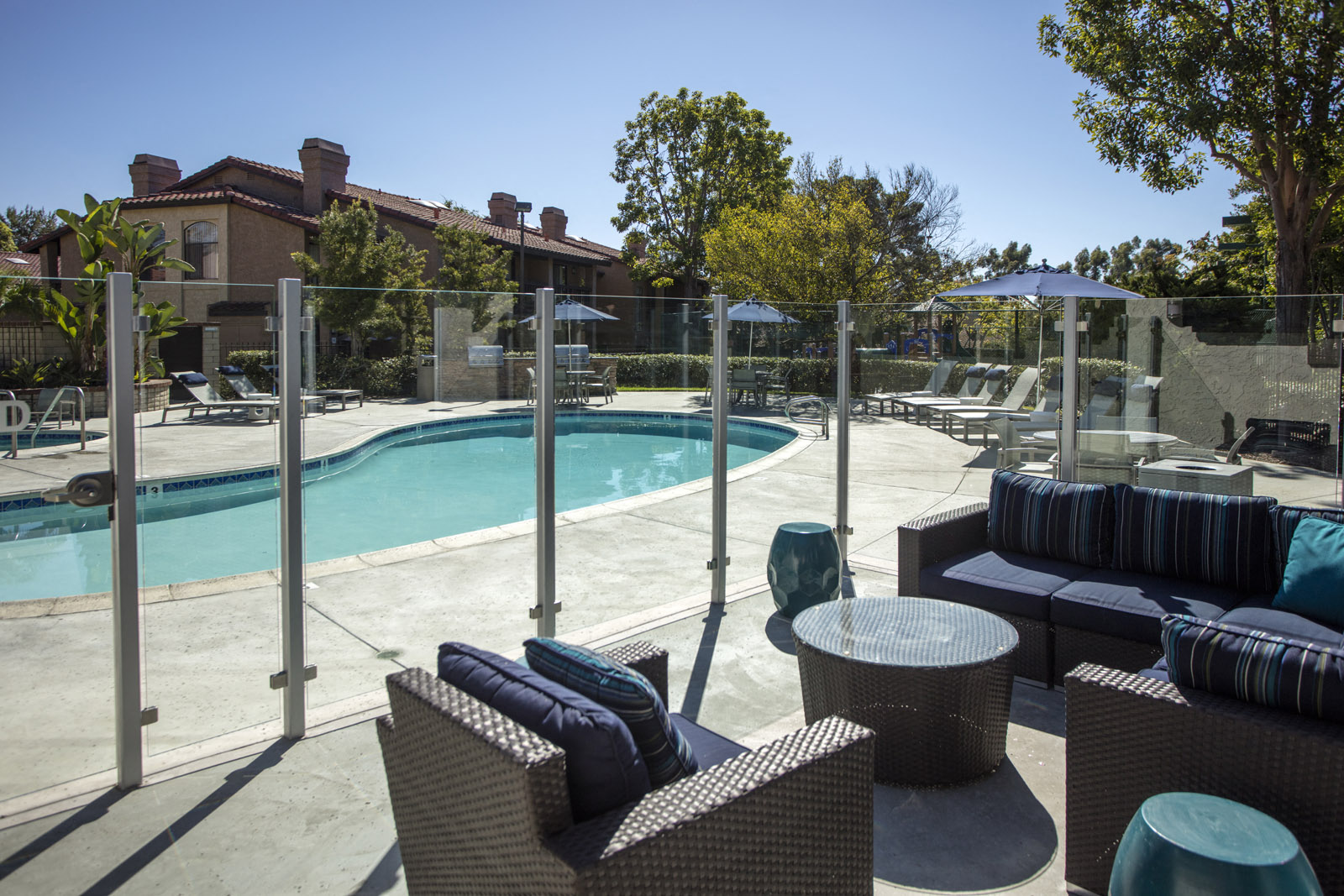 Seating area adjacent to pool with glass partition fence