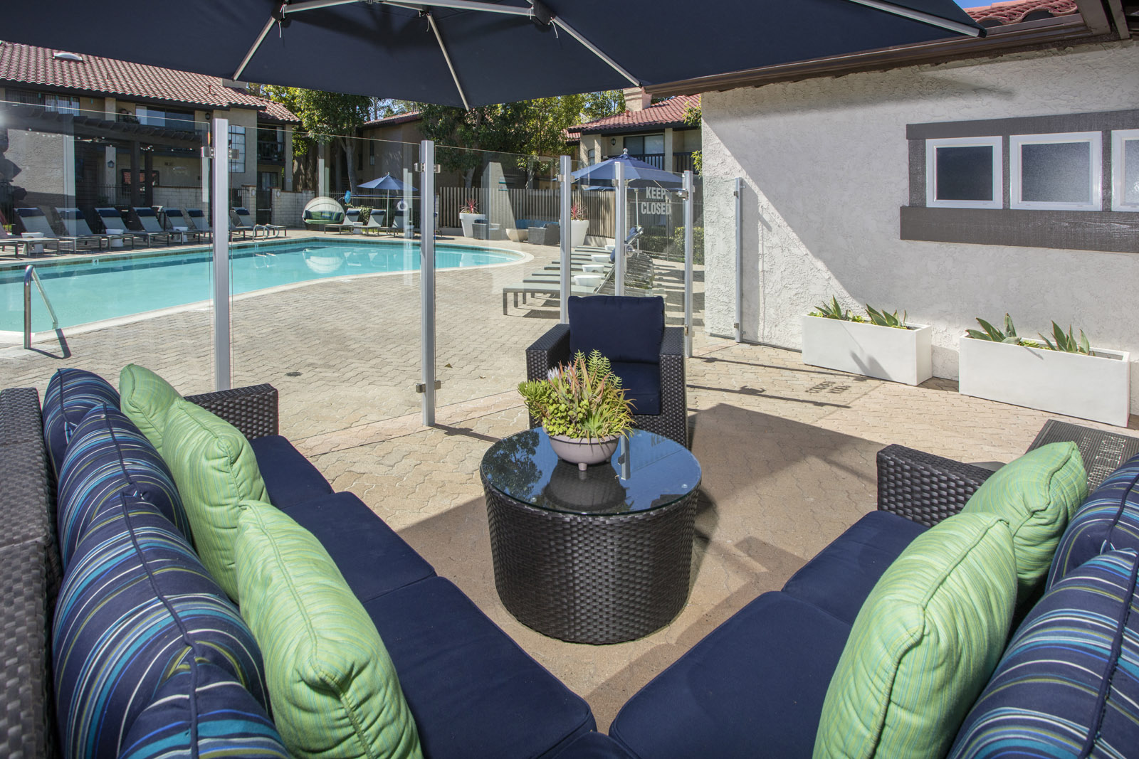 Seating area adjacent to pool with glass partition fence