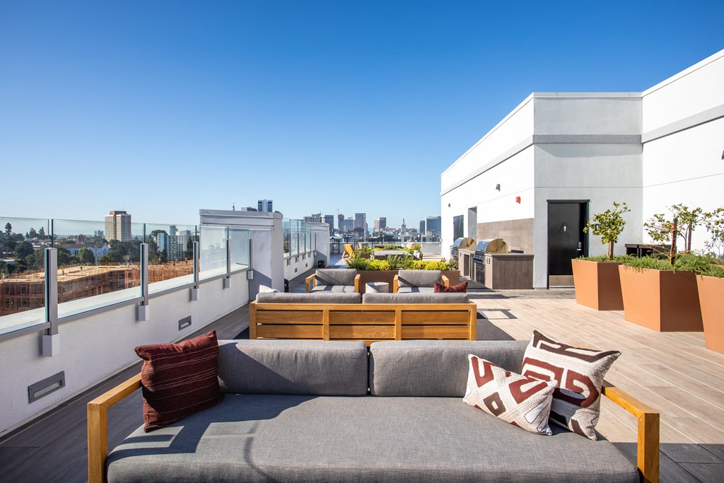 a roof top patio with a couch and a view of the city
