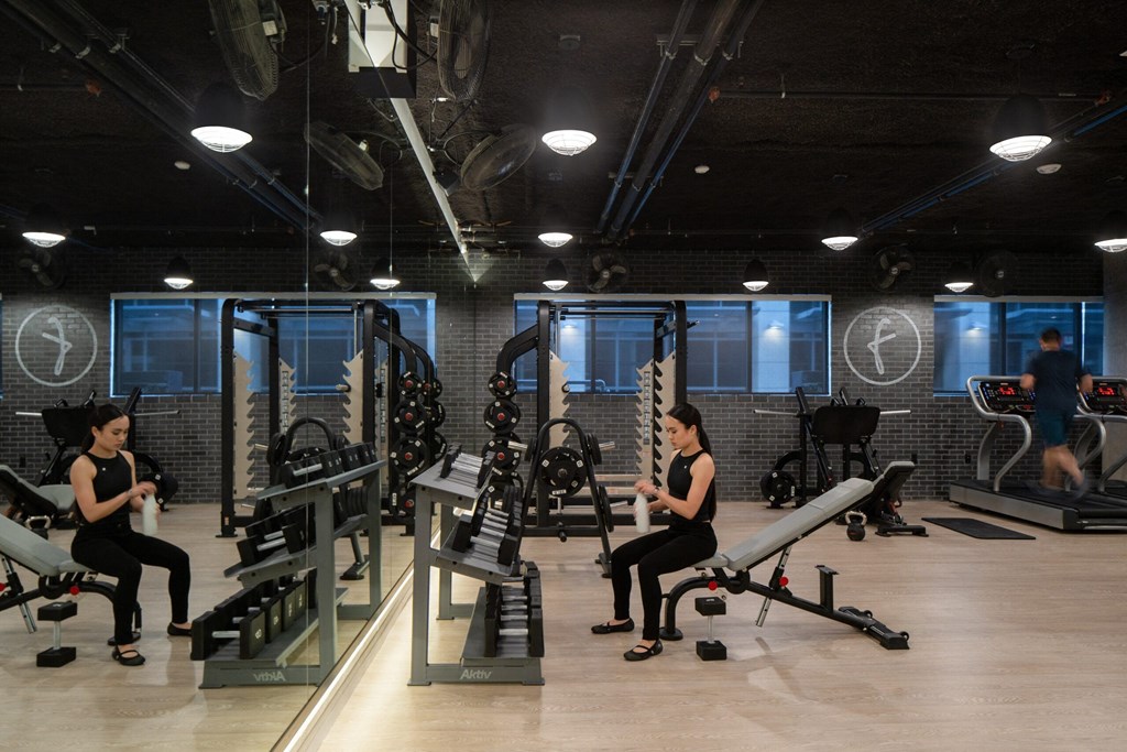 a woman exercising in a gym with weights and machines
