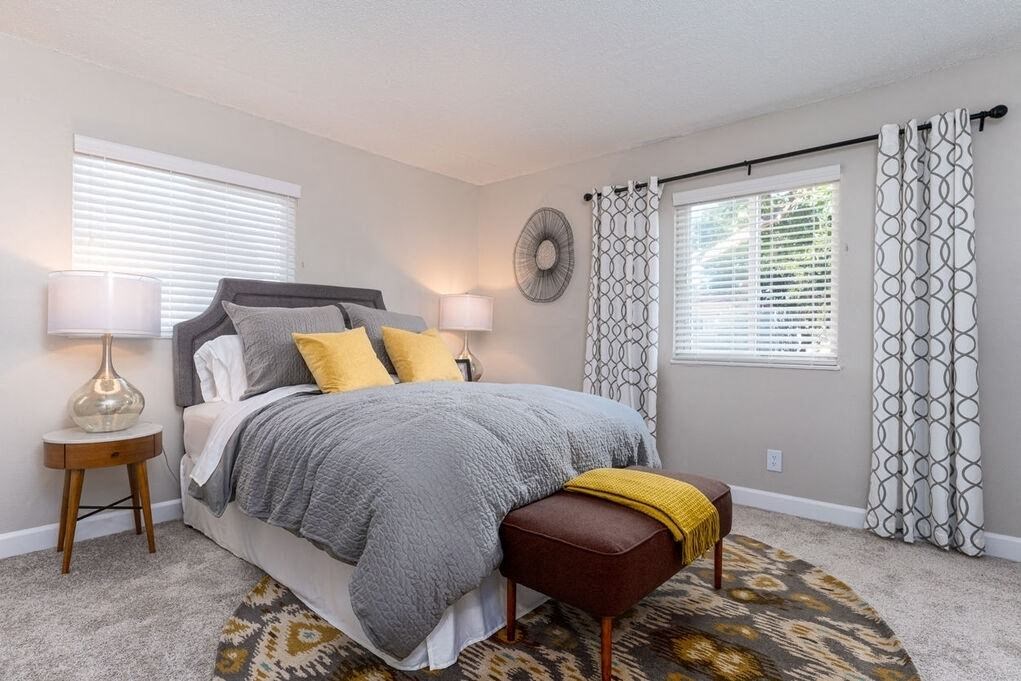 A bedroom with a bed, a side table, and a window at Nola 624 Apartments, West Covina, 91790