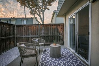 A patio with a table and chairs and a tree in the background at Nola 624 Apartments, West Covina