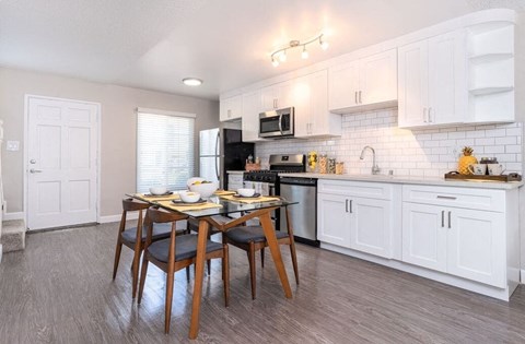 A kitchen with a table and chairs in the middle of it.