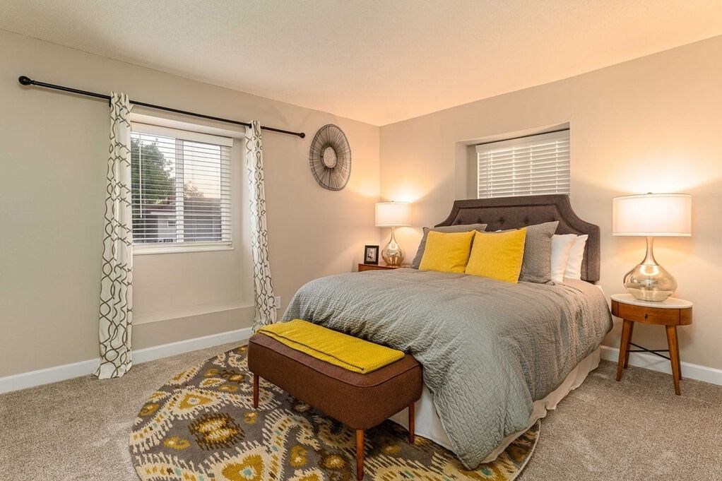 A bedroom with a bed, nightstand, and window with curtains at Nola 624 Apartments, West Covina, 91790