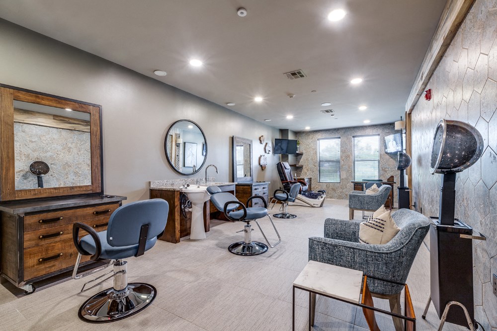 Senior Living In Prosper, TX - Alders Prosper - Hair And Nail Salon With Salon Chairs, Hair Dryer Machines, Hair Wash Bowl, Pedicure Massage Chair, TV, And Mirrors