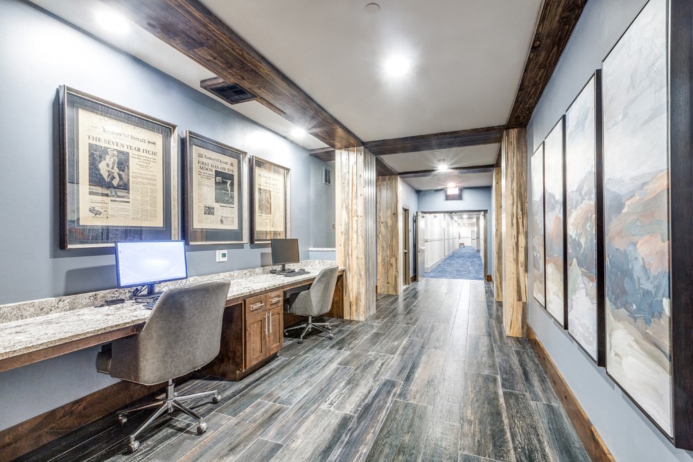 a lobby with desks and chairs and a hallway with paintings on the wall