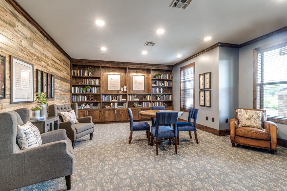 Luxury Apartments In Prosper, TX - Alders Prosper - Library With Books, Table, Chairs, Couches, And Window For Natural Sunlight