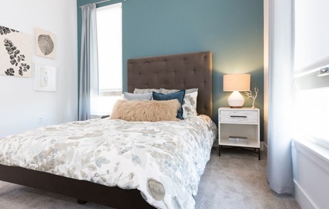 furnished model bedroom with large windows