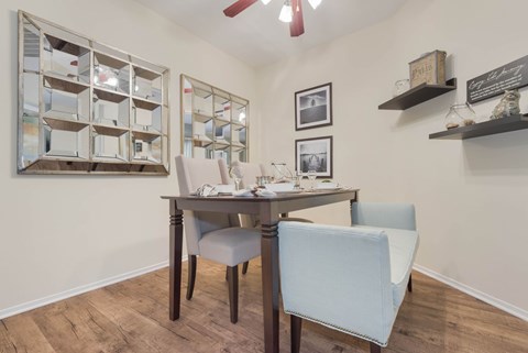 A dining room with a table and chairs.