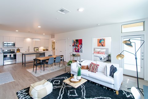 A modern living room with a white couch and a black and white rug.