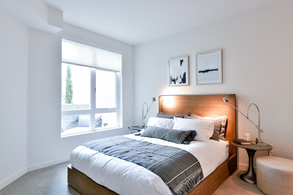 a bedroom with a bed and a large window