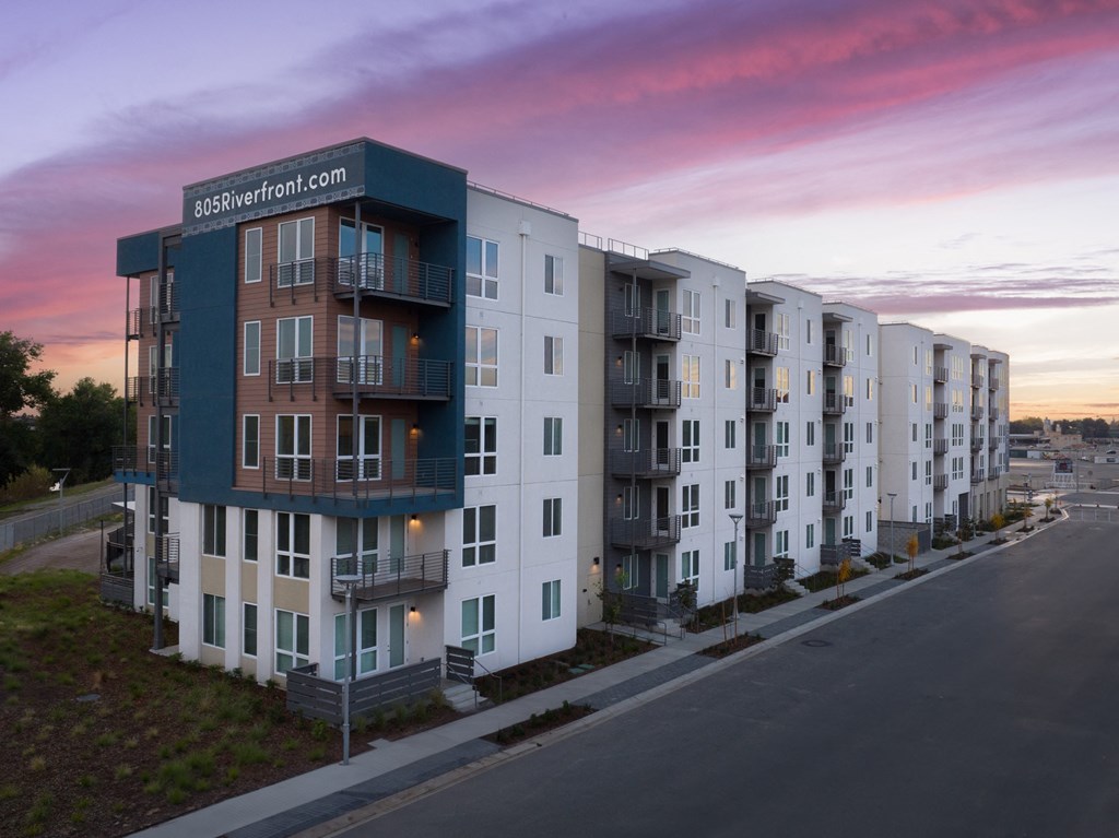 West Sacramento, CA Apartments - 805 Riverfront - Street View of Building Exterior at Sunset with White, Navy, and Gray Details
