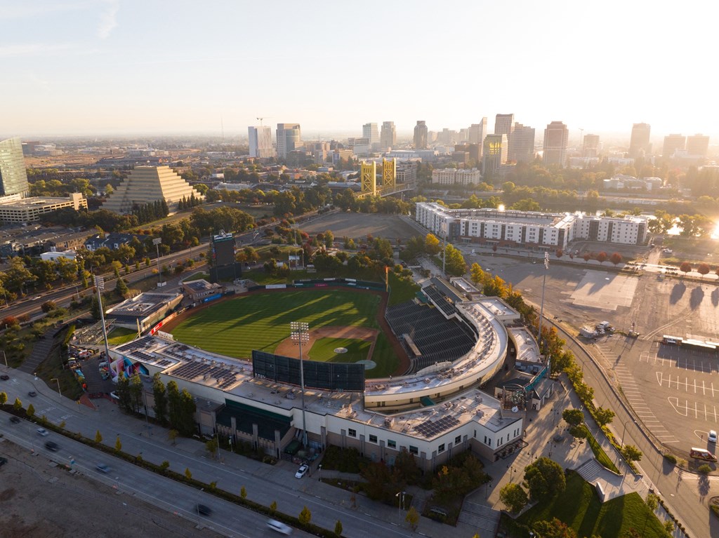 an aerial view of a baseball stadium with a city in the background