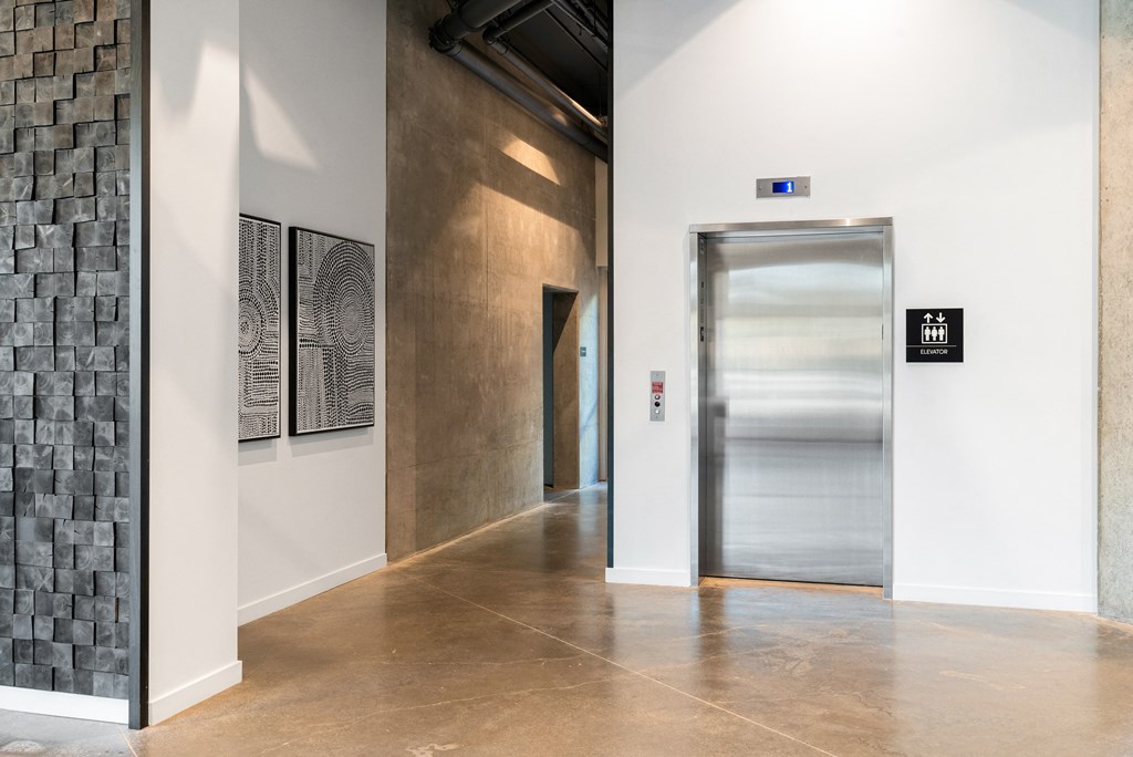 lobby with an elevator and paintings on the wall