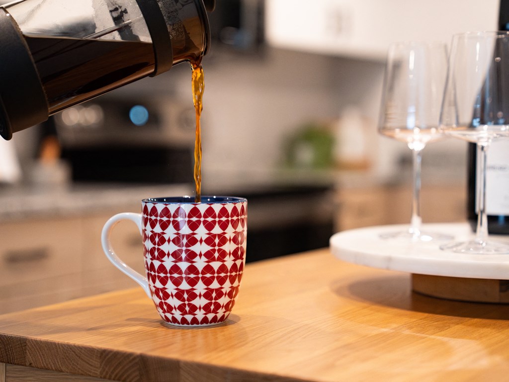 a coffee being poured into a coffee mug on a kitchen counter