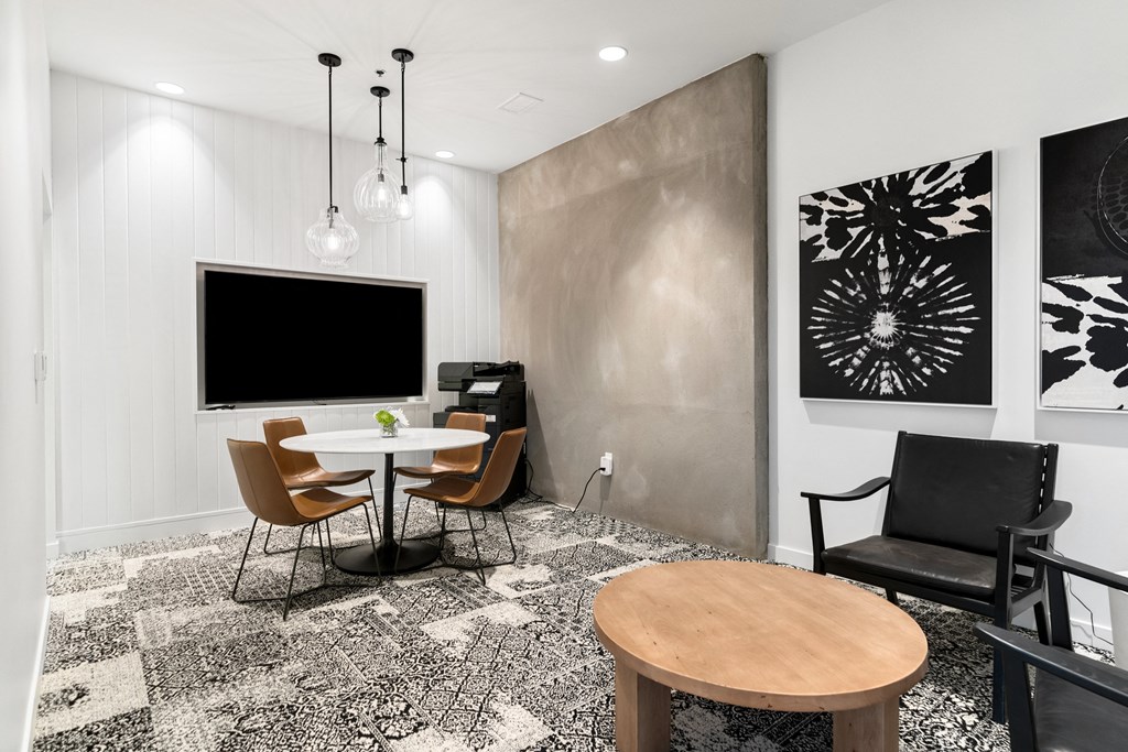 a conference room with a table and chairs and a television