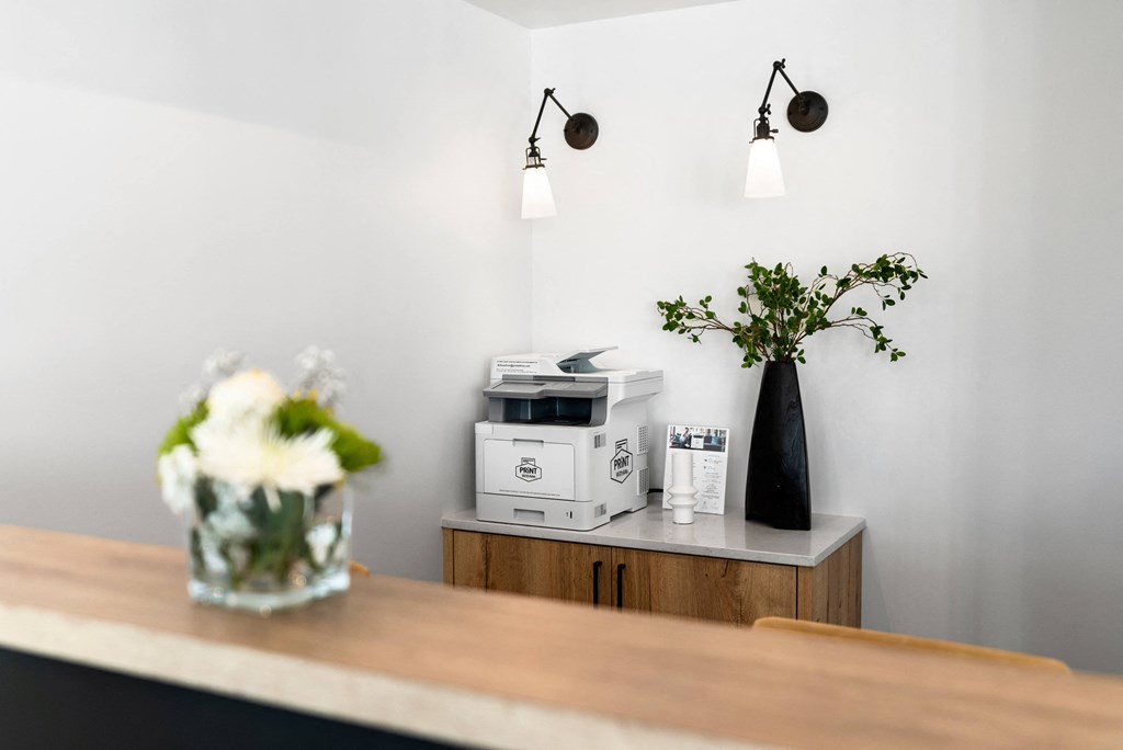 a kitchen counter with a microwave and a vase with flowers