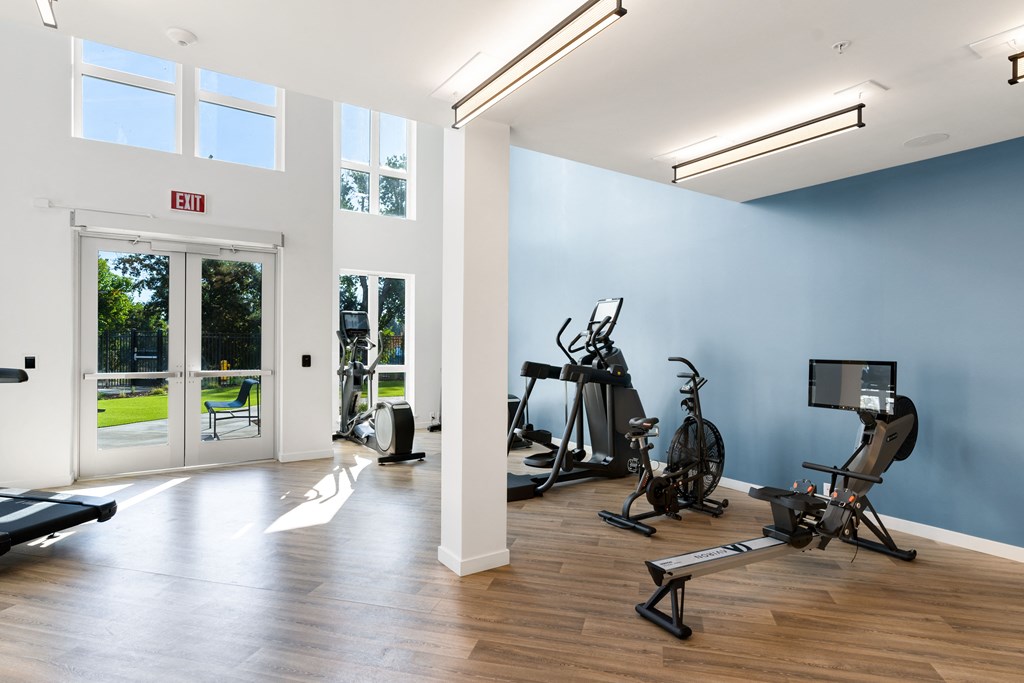 a gym with exercise equipment and a door to a patio