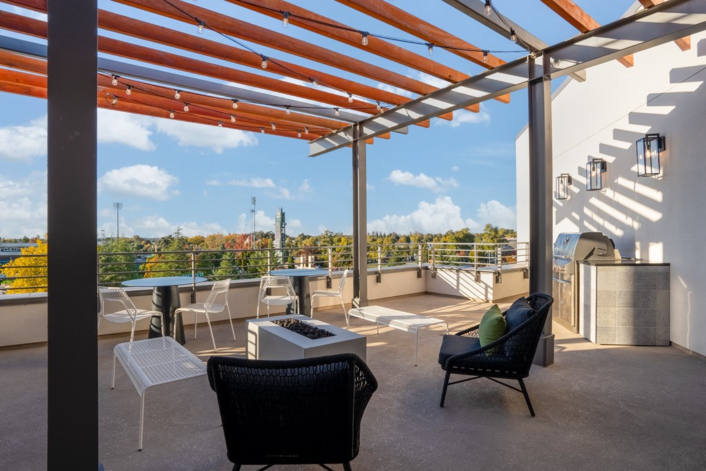 a rooftop patio with chairs and tables and a view of the city