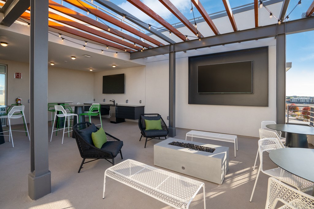 a lounge area with chairs and tables and a television