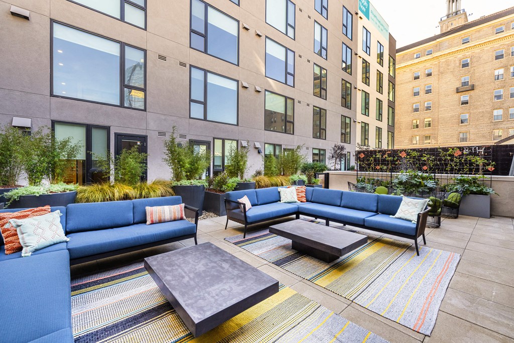 a communal area with couches and tables in front of an apartment building