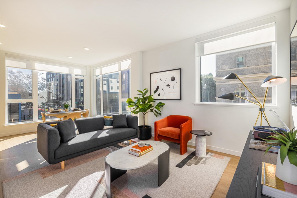 a living room with a couch and a coffee table and large windows